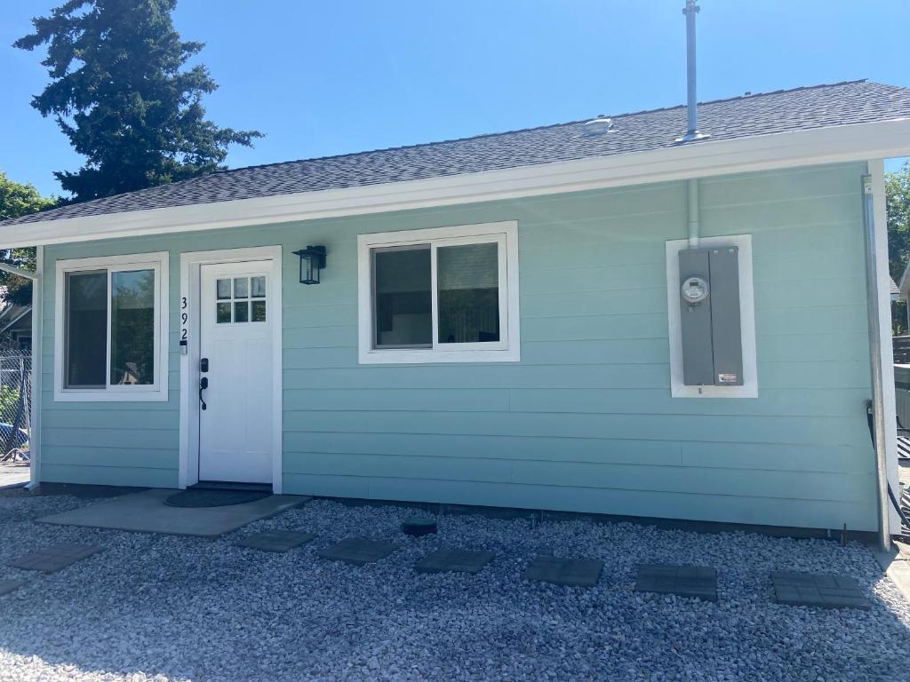 a green house with a white door and windows at Newer Cozy Guest Cottage with Saltwater Spa! in Weed
