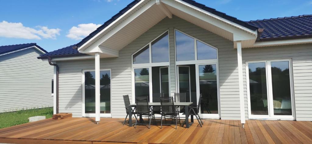 a deck with a table and chairs on a house at Ferienhaus-Elbblick-Haselau in Haselau