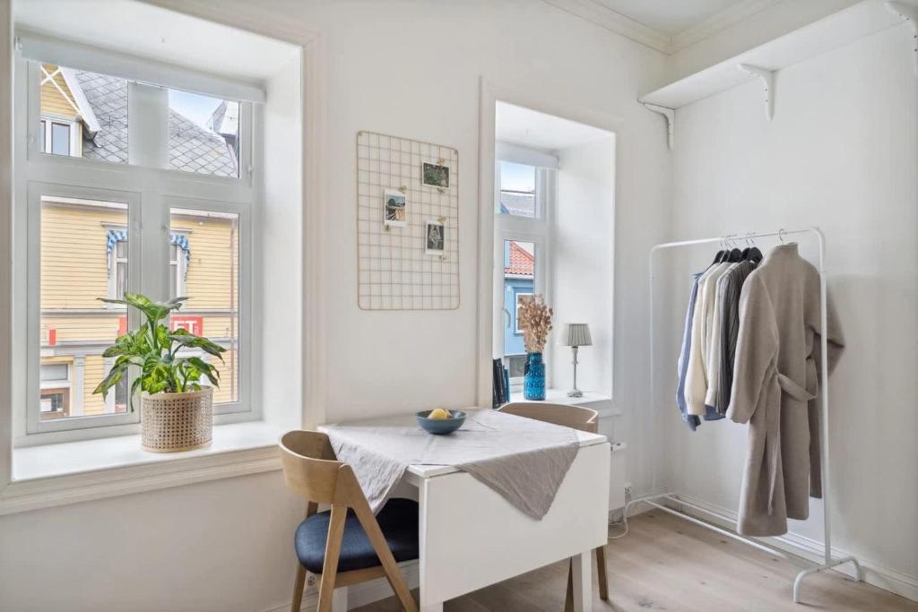 a white room with a table and two windows at Central and modern in Tromsø