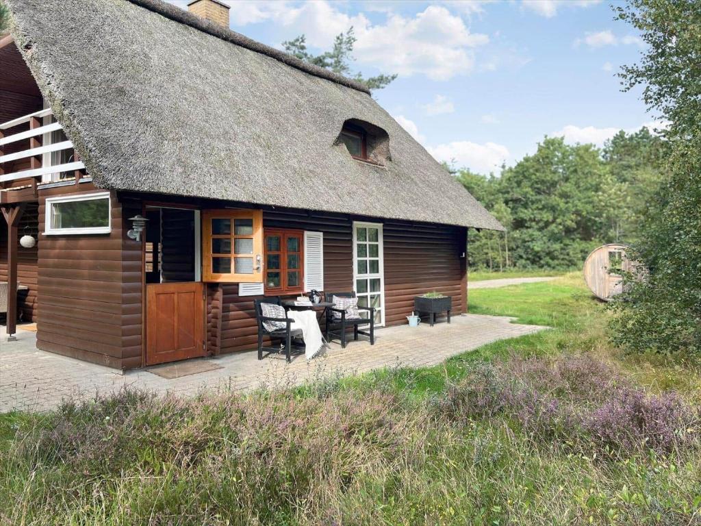 a small house with a patio and a table at 0310-Romo-Langdalsvej-61 in Høm