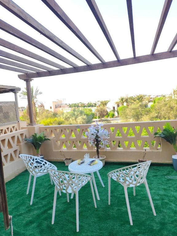 a patio with a table and chairs on a green carpet at Rihana 2 bedrooms in Hurghada