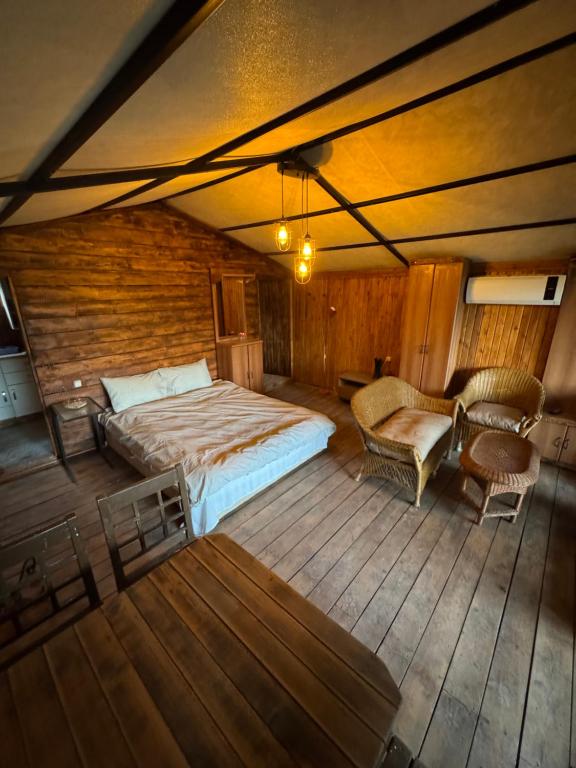a bedroom with a bed and chairs in a room at İncir Bungalov Karavan Park Efes-Kuşadası in Aydın
