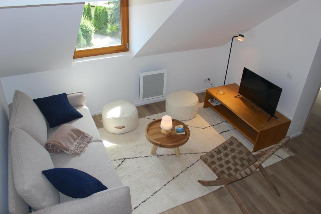 a living room with a couch and a television at Grand duplex ensoleillé pour 7 Résidence Violaine in Le Monêtier-les-Bains