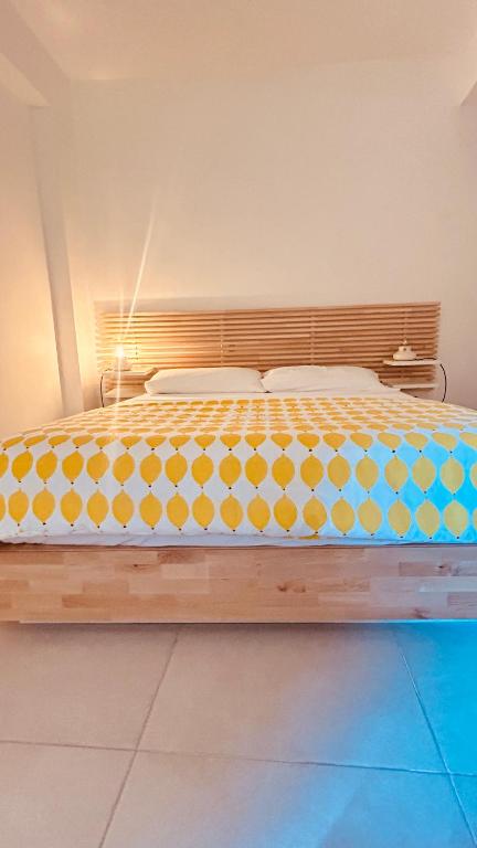 a large bed with yellow and blue polka dots on it at Casa Morgana camera Irene in Scilla