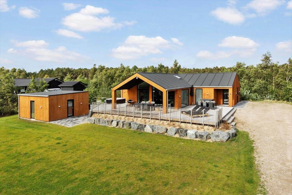 a house with a black roof on a green field at 0364-Romo-Vestergardsvaenget-7 in Høm
