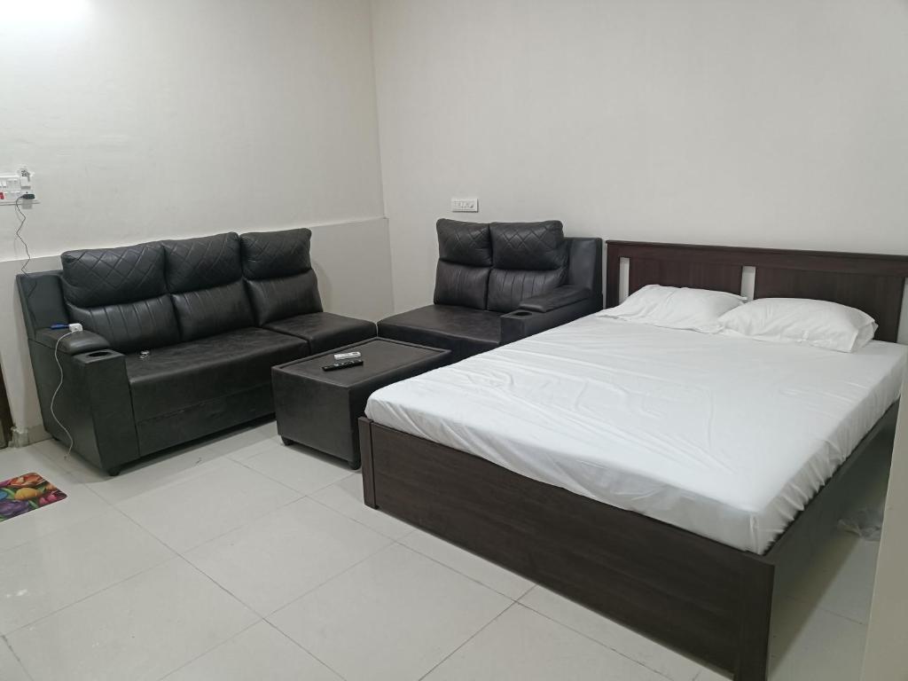 a bedroom with a bed and a couch at RVR TOWN LODGe 