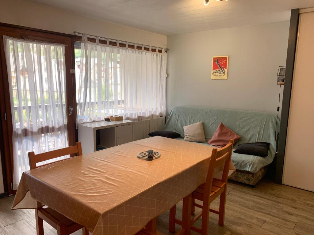 ein Wohnzimmer mit Tisch und Couch in der Unterkunft Appart T2 Cabine Village Saint Lary Soulan in La Celle-sous-Gouzon