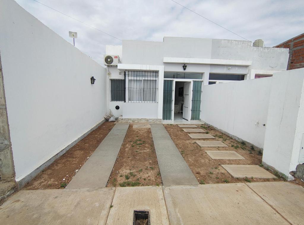 Un edificio blanco con un camino que conduce a él. en Apartamento Los Churquis, en Rosario de la Frontera