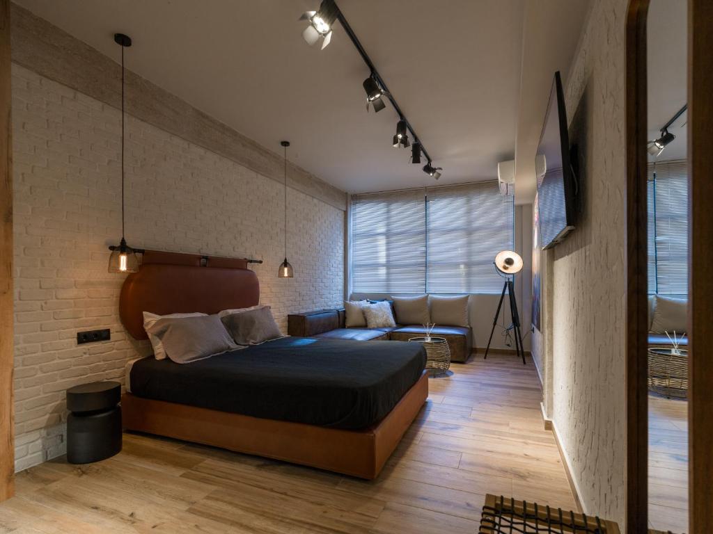 ein Schlafzimmer mit einem Bett und einer Couch in der Unterkunft Bee plus by CityBee in Athen