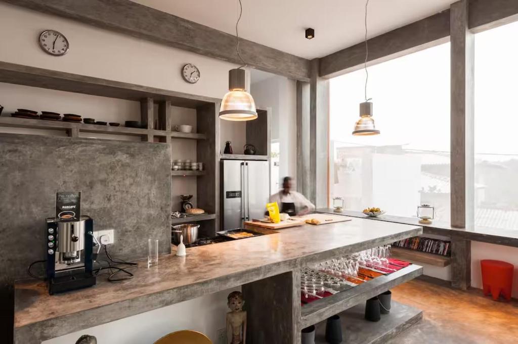 a kitchen with a long counter with a person in the background at Super Villa In Unawatuna Sunny beach in Kadawatha