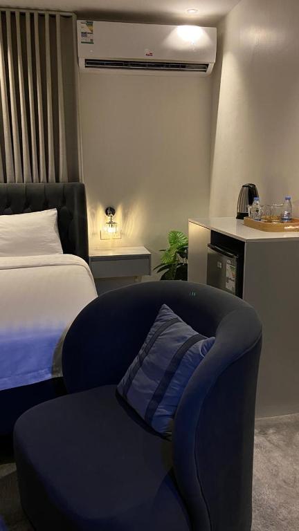 1 dormitorio con 1 cama y 1 silla con almohada en Calm Studio, en Yeda