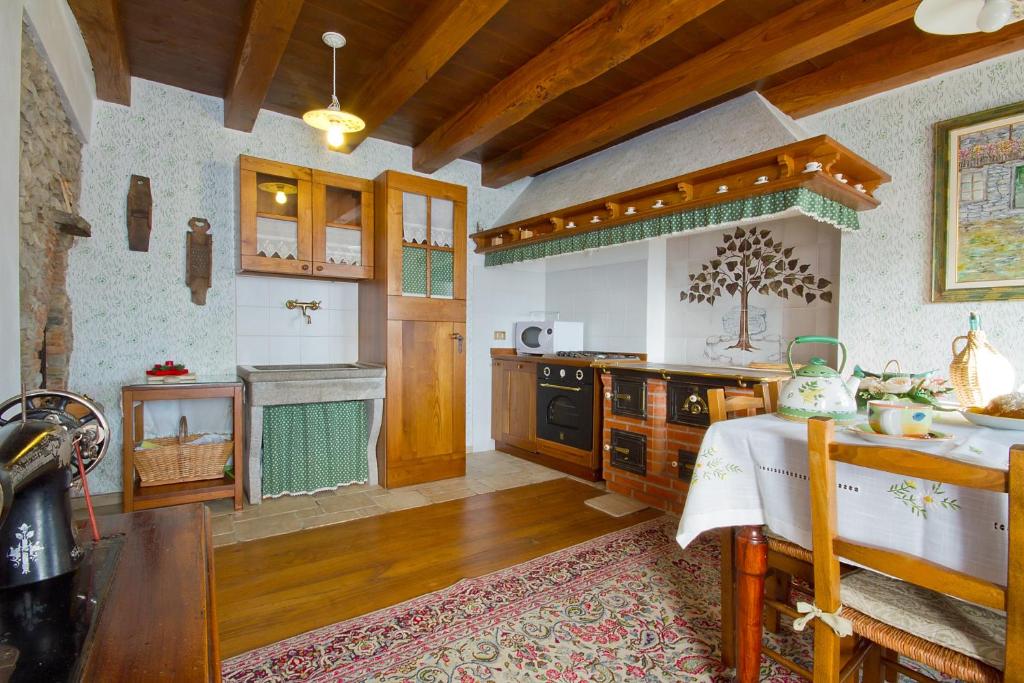 uma grande cozinha com uma mesa e um fogão em Casa Krajnova em Oblizza