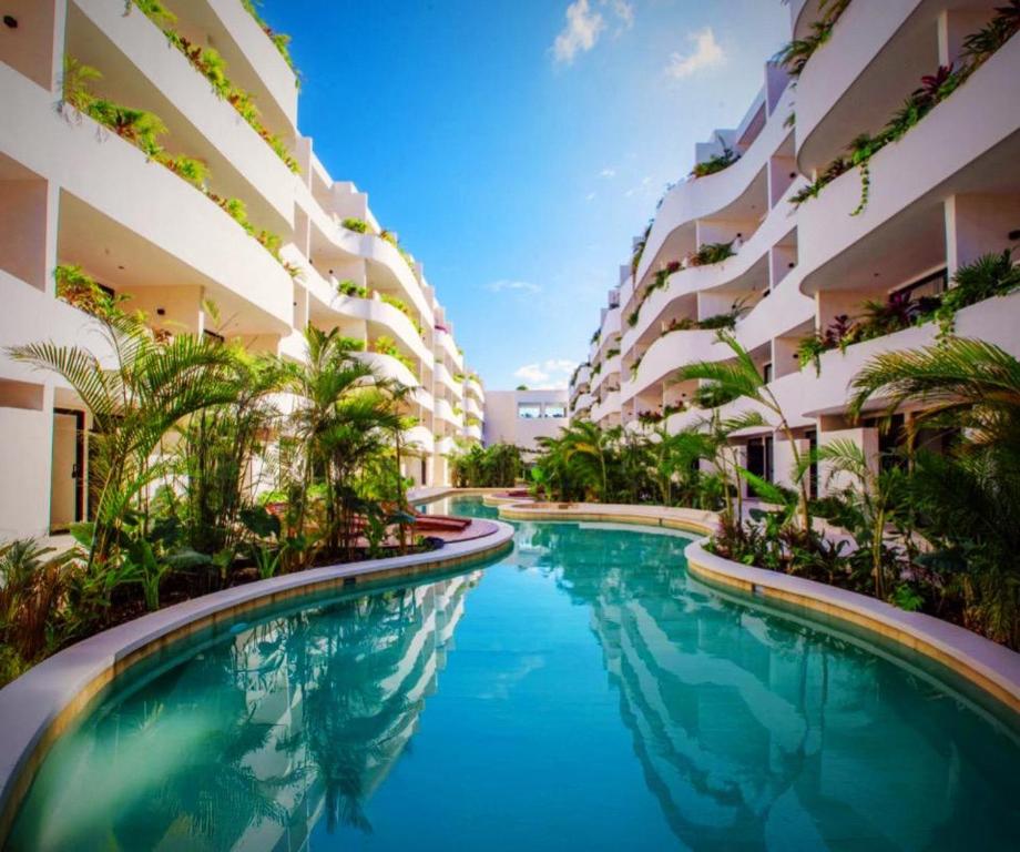 a swimming pool in front of a building at Tulum Getaway with Jacuzzi & Pools in Tulum