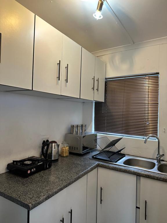 Una cocina con gabinetes blancos y encimera. en The Tranquil Ridge, en Hilton