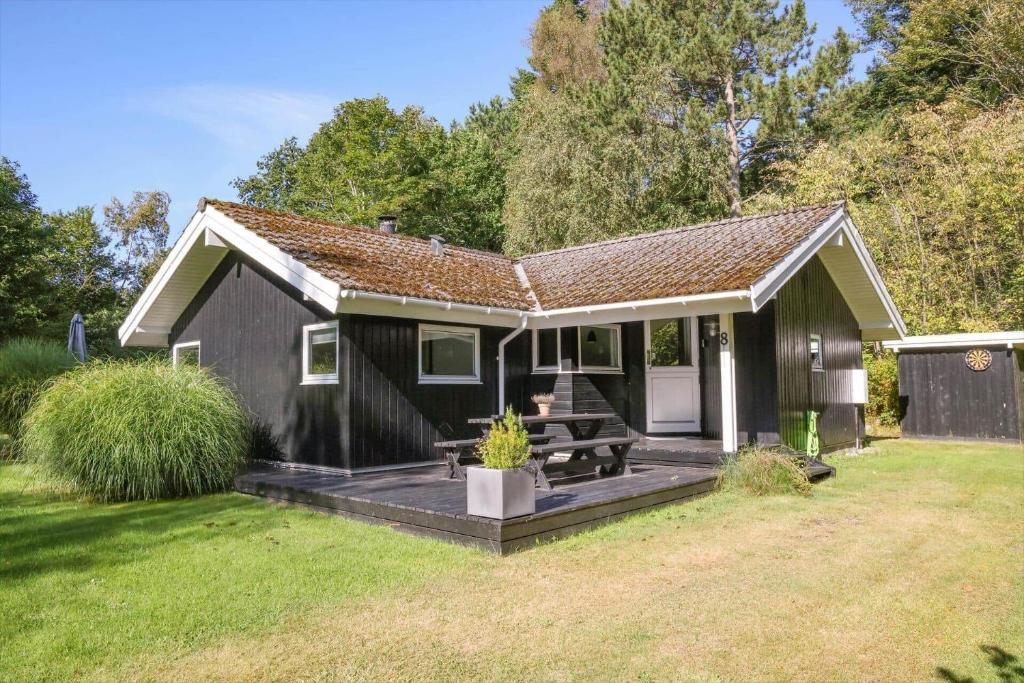a small black house with a deck in the yard at 13337-1-Hojby-Annettevaenget-8 in Højby