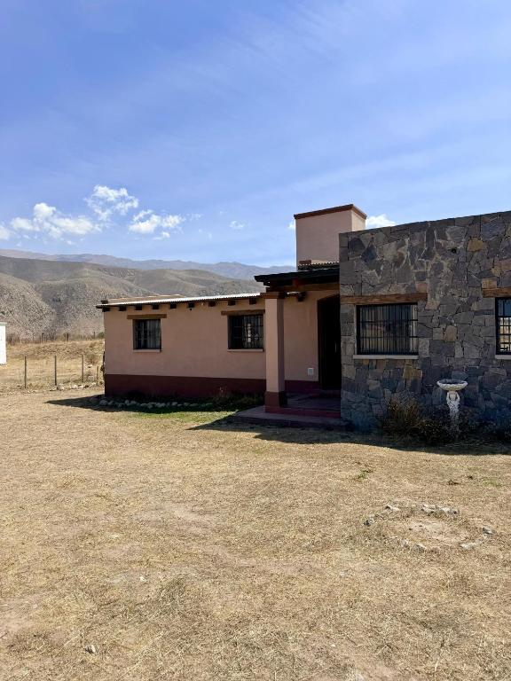 a house in the desert with mountains in the background at Los Leños in Tafí del Valle