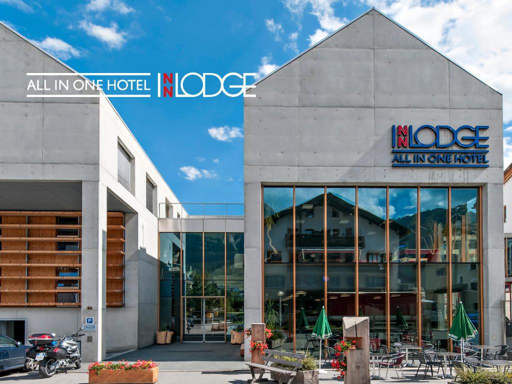 un hotel norge con mesas y sillas frente a un edificio en All In One Hotel - Inn Lodge / Swiss Lodge en Celerina