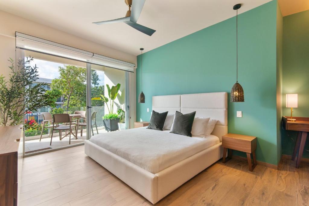 una camera da letto con un letto bianco e un balcone di Estudio Balaam a Playa del Carmen