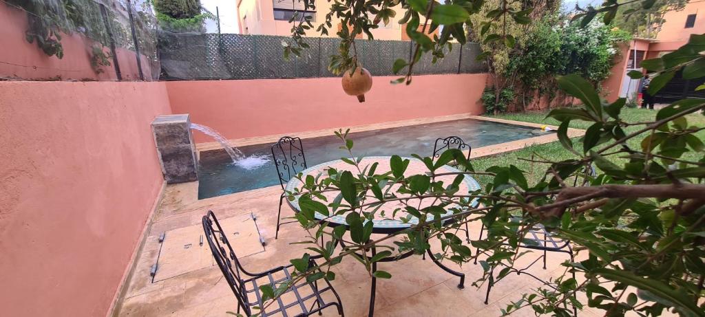 a pool with two chairs and a table and a plant at 5-star luxury villa with private pool in Marrakech