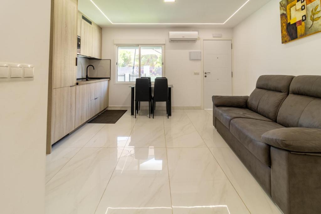 Una sala de estar con un sofá y una cocina. en Villa Amir, en Fuengirola