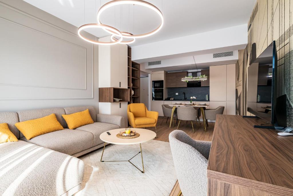 Maison Lumière - A modern Designer Apartment in Central Bucharest في بوخارست: غرفة معيشة بها أريكة وطاولة