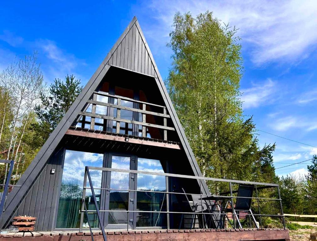 a house with a triangular roof with a large window at Diamond chalet in Ogrody