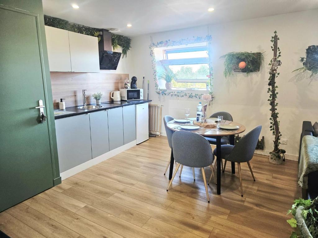 a kitchen and dining room with a table and chairs at Appart 7Om2 Atypique "Forêt enchantée" tout confort à 20 minutes de Lille et Arras in La Bassée