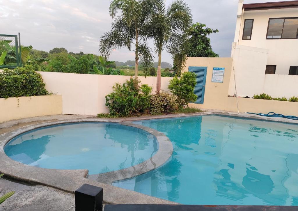 une piscine devant un immeuble dans l'établissement Auntie's, à Tanza