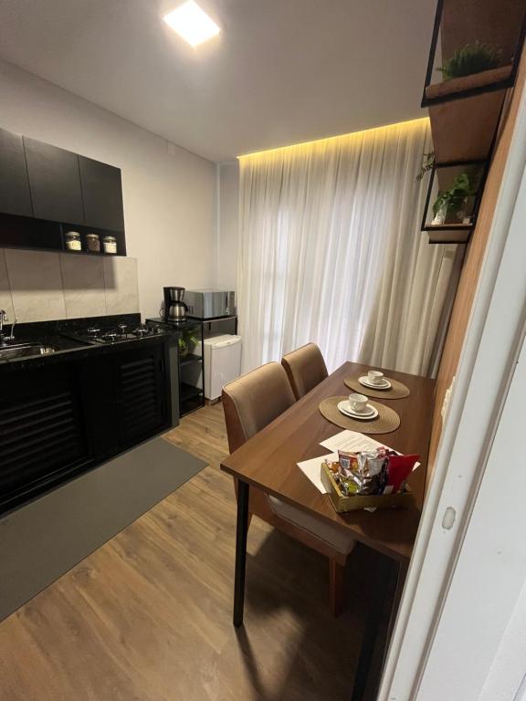 a kitchen and dining room with a wooden table and chairs at Studio aconchegante e tranquilo! Perto de tudo! in Indaial