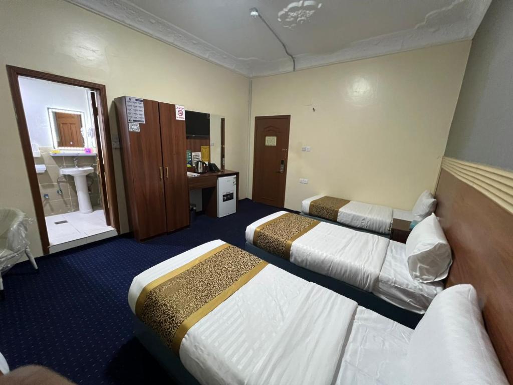 a hotel room with two beds and a bathroom at فندق حمودة الماسي in Al Madinah