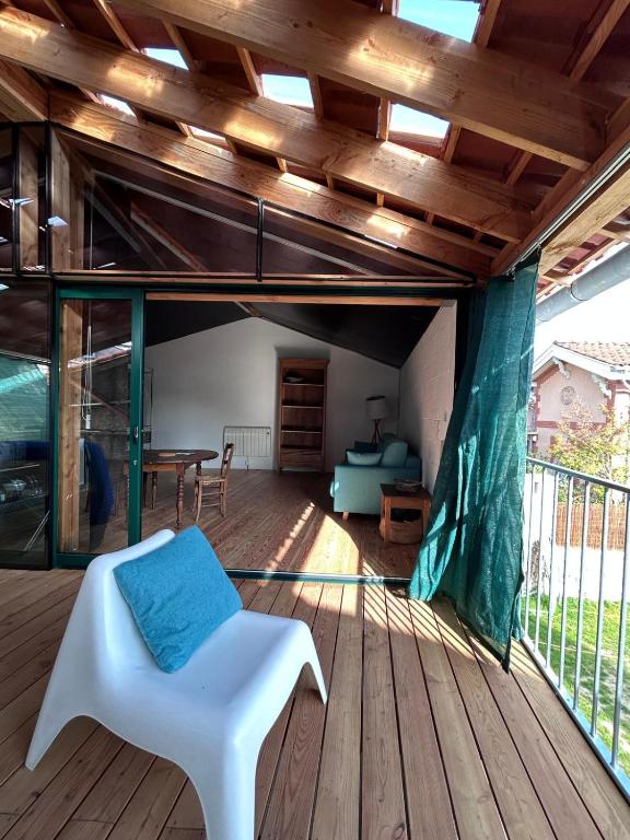 een open dek met een witte stoel en een tafel bij Logement avec terrasse in Toulouse