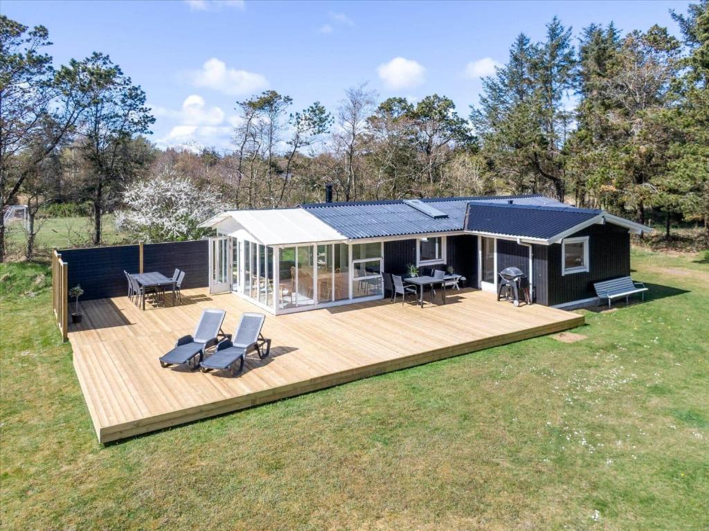 156-Ringkobing-Birkealle-14 في Nørby: منزل عليه سطح وكراسي