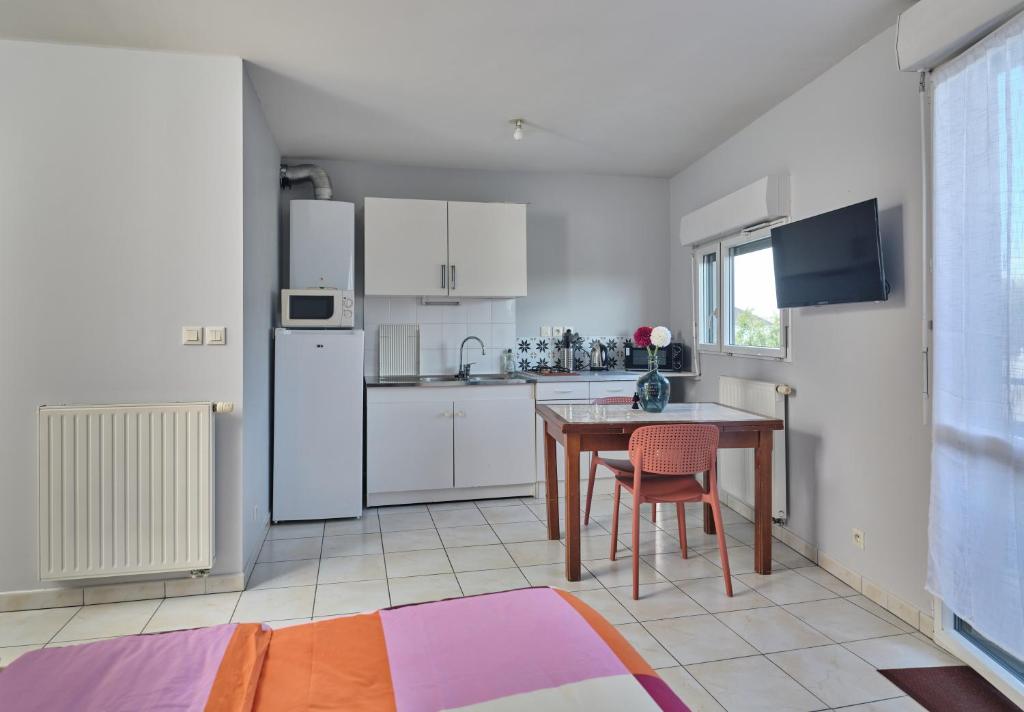 Akwaba chez Paule في نانت: مطبخ مع طاولة وثلاجة بيضاء