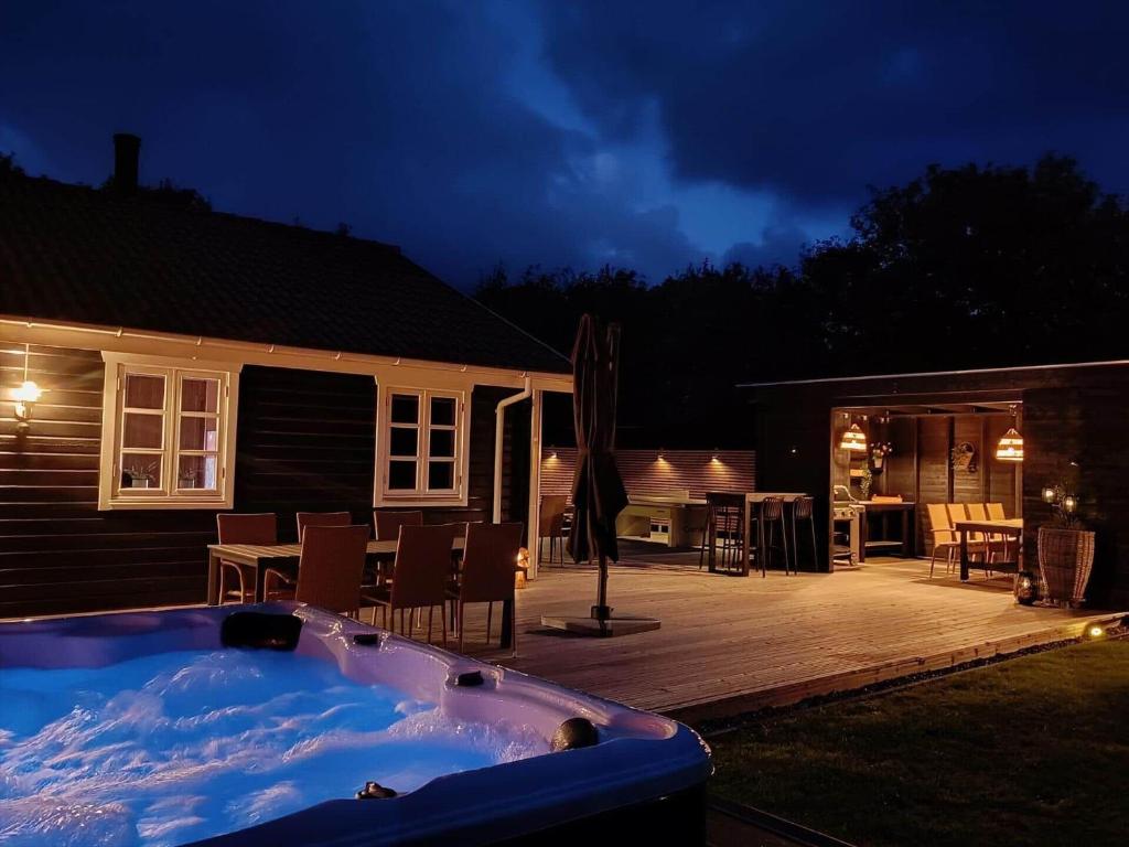 a backyard with a hot tub and a patio at 1093-ringkobing-Fyrrealle-3 in Ringkøbing