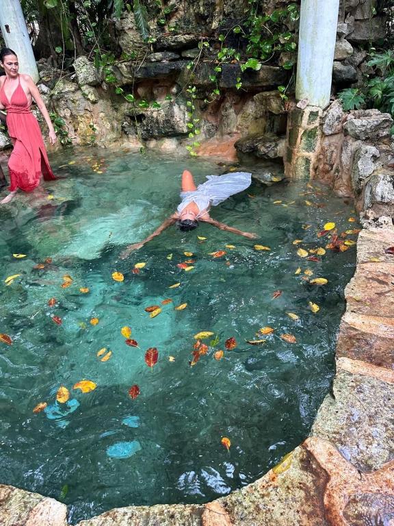 a person laying in the water with an umbrella at Casa caracol Macario in Macario Gomez