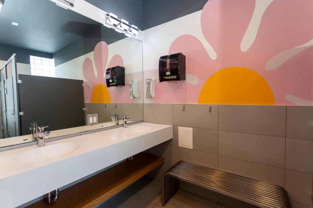 Un baño con dos lavabos y un espejo grande. en Chicago Parthenon Hostel, en Chicago