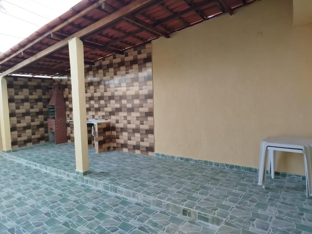 una stanza con un muro di mattoni e un tavolo su un patio di Casa de Temporada em Monte G & Guarajuba a Monte Gordo