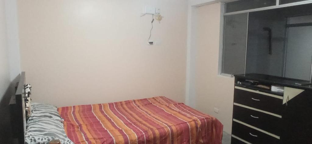 ein Schlafzimmer mit einem Bett und einem Flachbildfernseher in der Unterkunft Departamento amoblado y comodo in San Vicente de Cañete