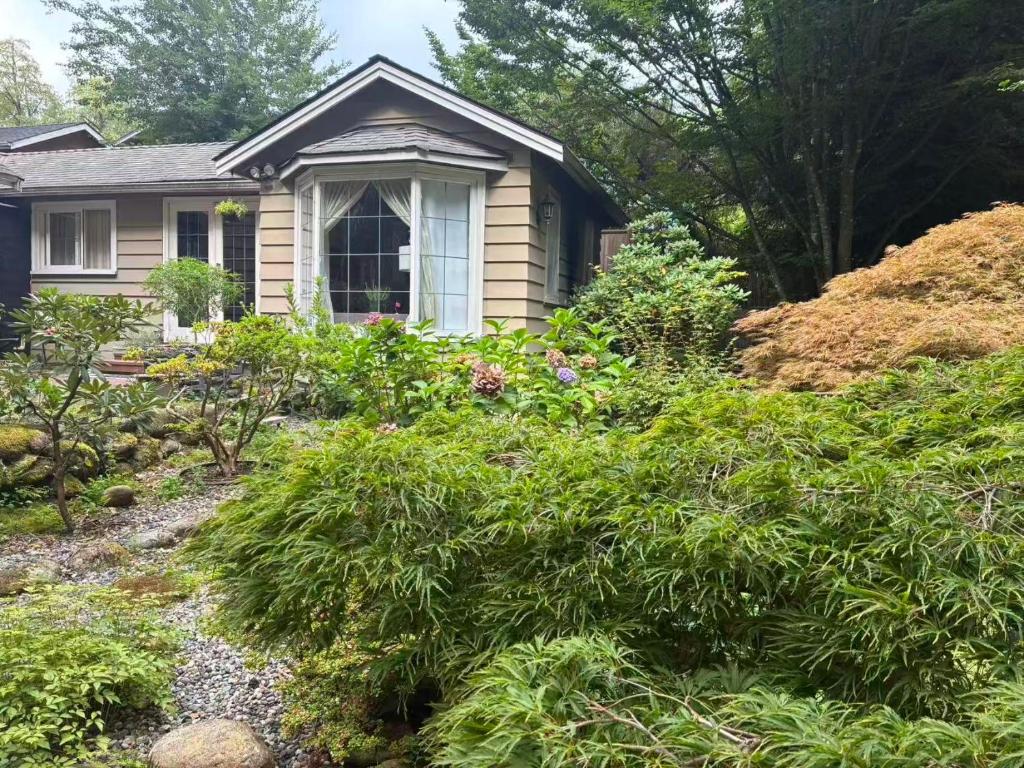 Una casa con un montón de plantas delante de ella. en Suit near Grousmountain, en North Vancouver