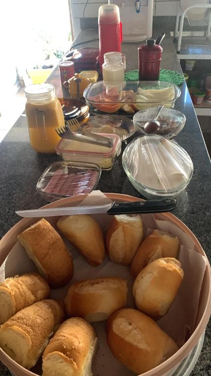 a table with a bunch of bread in a basket at Refúgio aconchegante no coração da cidade in Carolina