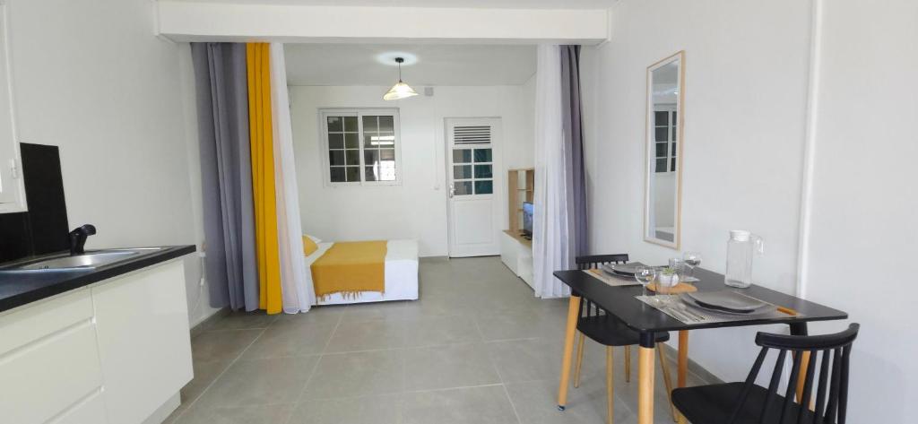 a kitchen with a table and a dining room at La Fleur Doré Studio in Le Vauclin