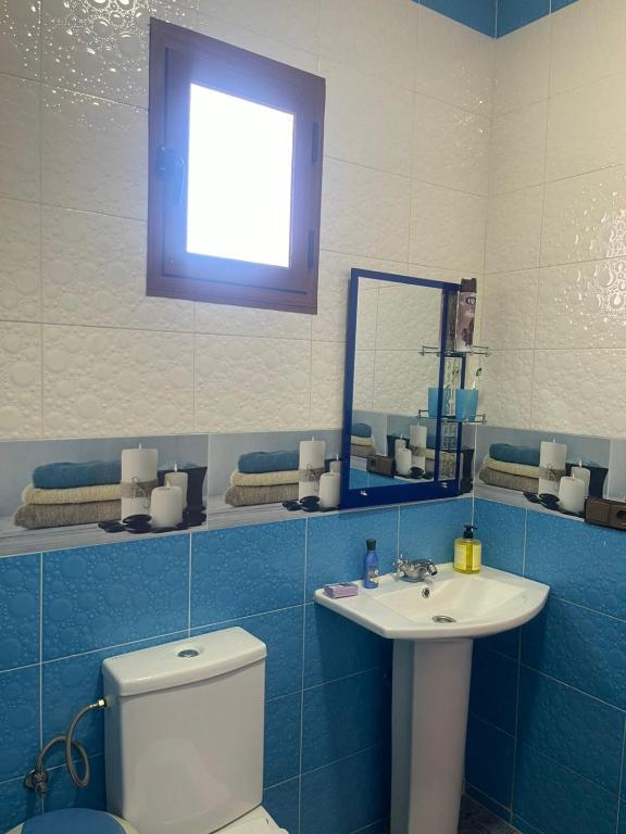 a bathroom with a toilet and a sink and a mirror at VERSE 5 min de la playa in Riffiene