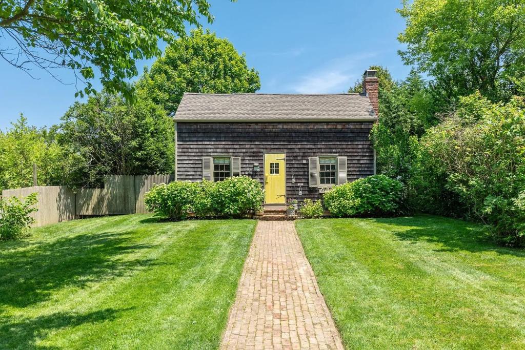 une maison en briques avec une porte jaune dans une cour dans l'établissement 1800 Historical East Hampton Home, 1 Mile to Town!, à East Hampton