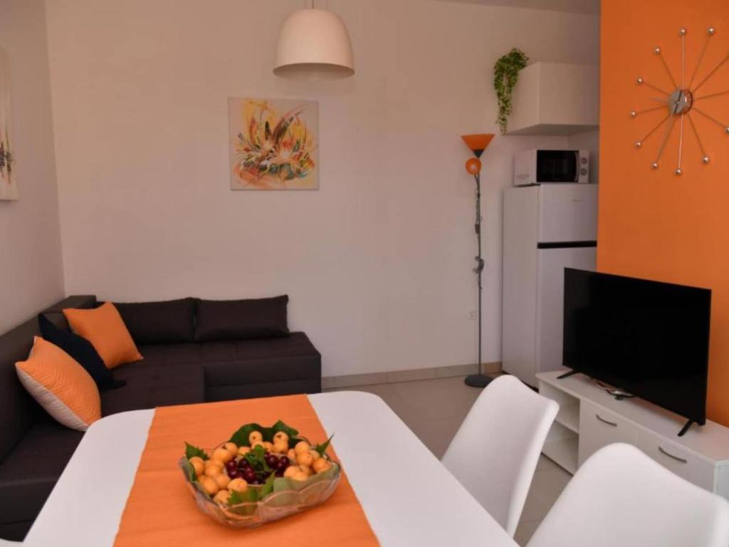 a living room with a table with a bowl of fruit on it at One Bedroom Apartment with Terrace & Garden View in Supetar