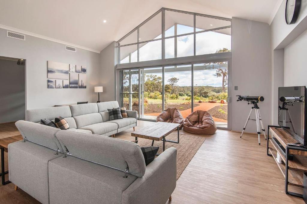 ein Wohnzimmer mit Sofa und Tisch in der Unterkunft Skibo House - A Family Retreat near Margaret River in Witchcliffe