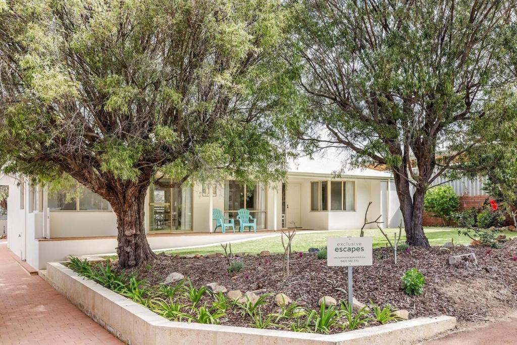 a sign in front of a house with trees at Reverie By The Bay - Walk to Beaches, Relax in Style in Dunsborough