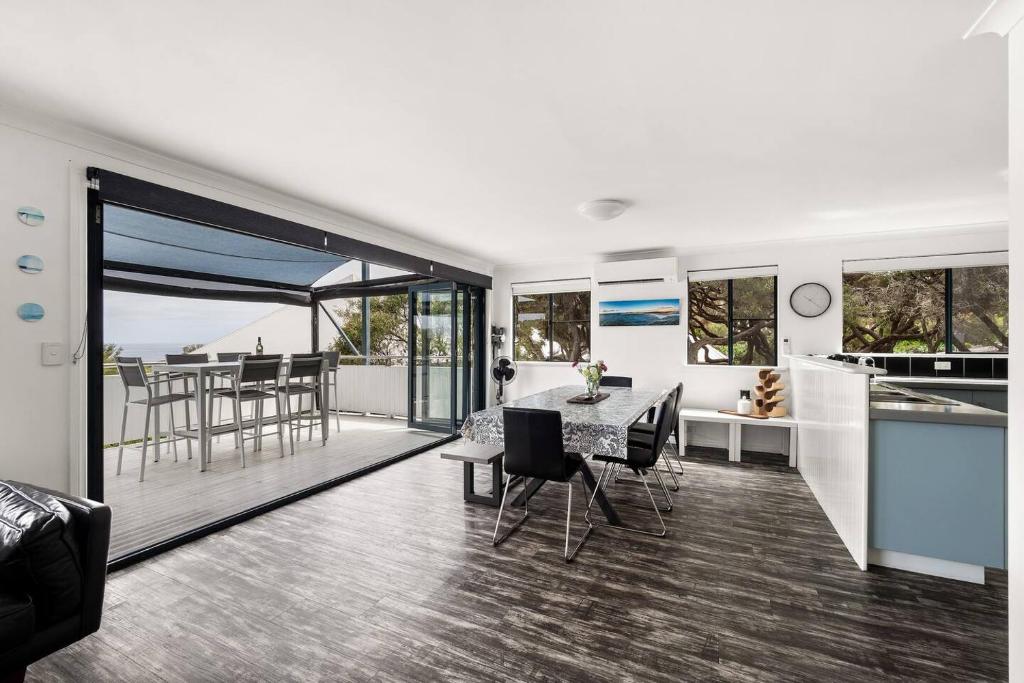a kitchen and living room with a table and chairs at Surfers Paradise - Oceanview Garden Beach House in Yallingup