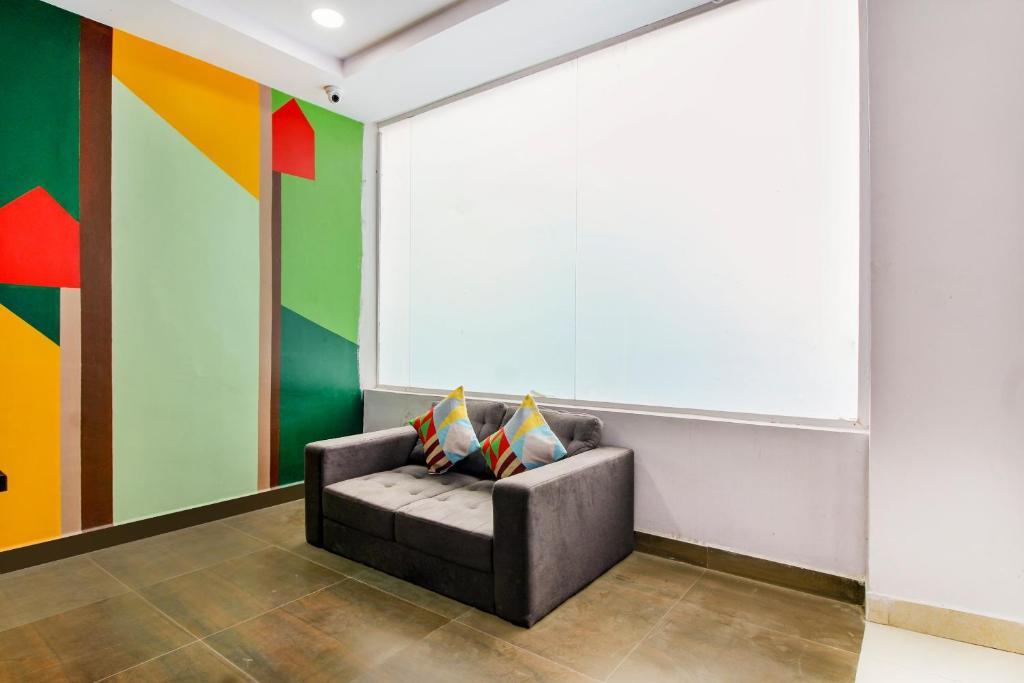 Hotel O PRAMOD PRIME HOMES في Surūrnagar: أريكة في غرفة ذات جدران ملونة