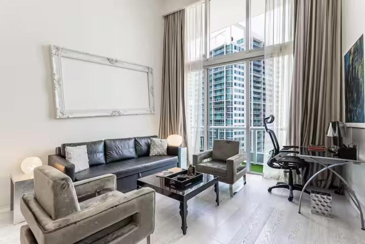 a living room with a couch and a table at Beautiful Icon Brickell Double height ceiling in Miami