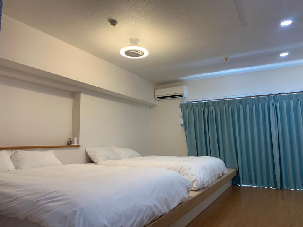 福岡市にあるグランドキャニオンのベッドルーム1室(ベッド2台、青いカーテン付)